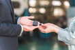 © buritora - Salesman taking car keys from female customer, male salesman staff