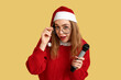 © Pixel-Shot - Young female journalist in Santa hat on yellow background