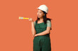 © Pixel-Shot - Female Asian painter with paint brush on orange background