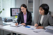 © Wasana - Asian businesswomen working together using data from charts and graphs displayed on computer screen