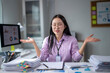 © Wasana - Stressed asian businesswoman showing resignation gesture at office desk