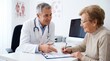 © ibhonk - Mature male physician in a white lab coat explaining medical documentation to an elderly woman signing papers at his office desk.