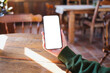 © Farknot Architect - Mockup image of a woman holding and using mobile phone with blank desktop screen in cafe