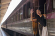 © Phimwilai - Young woman waving goodbye from moving train