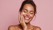 © LimeSky - Light skinned woman with radiant skin applying moisturizer or sunscreen on a pink backdrop Skin care and beauty treatments