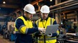 © Aqeela - Two industrial engineers in protective gear collaborate reviewing data on a modern laptop computer