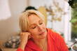 © Maskot - Relaxed blond senior woman leaning on elbow with eyes closed