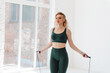 © Cavan Images - Stunning lady in sport clothing jumping alone with rope