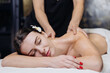 © wedmoments.stock - Female client receiving a relaxing back massage in a spa, therapist’s hands applying pressure, flower in her hair. Concept spa, massage, relaxation, wellness.