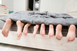 © Antonio - Feet of parents and children lying under the blanket