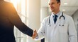 © twilight mist - Professional male physician and businessman shake hands inside a brightly lit building