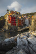 © Travel 'n' Lifestyle - View of vibrant houses cascading down rocky cliffs towards the tranquil harbor waters, a picturesque scene of coastal charm, Riomaggiore, Liguria, Italy.