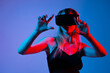 © Volodymyr_sh - Woman controlling virtual interface with both hands while wearing VR headset, immersive gesture control and futuristic technology