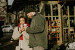 © BGStock72 - Korean woman and Caucasian man hold coffee cups outside a cafe in winter sunlight