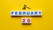 © Musfiqur - February twentieth date marked by small letter tiles and a gavel illustration against a vibrant yellow background