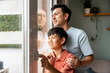© ADDICTIVE STOCK - Father and son looking out the window together