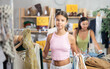 © JackF - Happy teenage girl choosing something for summer in clothing shop with large assortment