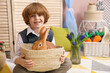 © New Africa - Little boy holding wicker basket with cute Easter bunny indoors. Space for text