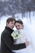 © New Africa - Happy newlywed couple with bouquet of flowers outdoors on winter day
