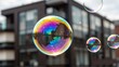 © IgorImageDoc - three soap bubbles floating air front modern building soap bubbles different sizes colors largest one center two smaller ones either side largest bubble larger than two has rainbow colored reflection