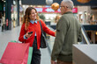 © Jelena - Woman with shopping bags talking to man in mall