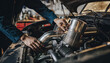 © justsann - Mechanic working on car engine in workshop.