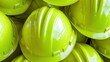 © FazStudio - A bright yellow hard hat with a ribbed design is stacked with other protective helmets in a close up view focusing on safety equipment for construction work