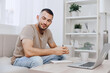 © SHOTPRIME STUDIO - Focused man working on his laptop at home, surrounded by cozy decor and greenery, creating a relaxed atmosphere for productivity. Perfect for modern lifestyle themes.
