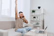 © SHOTPRIME STUDIO - Excited man celebrating success while talking on the phone. Bright and modern home office setting enhances the joyful atmosphere of achievement and connection.