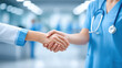 © javu - Medical nurse and doctor handshake in hospital corridor showing teamwork and trust