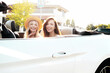 © halayalex - Portrait of two young beautiful and smiling hipster female in convertible car. Sexy carefree women driving. Positive models riding and having fun outdoors. Enjoying summer days. Cheerful and happy