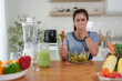 © crizzystudio - Woman grimacing holding her nose disliking healthy salad in kitchen