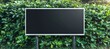 © Ilja - Blank advertisement panel surrounded by lush greenery, perfect for outdoor advertising campaigns.