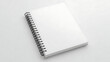© Digital - Spiral bound notebook mockup closed showing clean white pages and black wire binding on light background