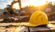 © Matthew - A worn yellow hard hat rests on wooden planks, with a construction excavator working in the background at sunset