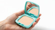 © narumiaegis - Woman's hand gently holds an open light blue compact powder case with a mirror, showcasing beauty makeup essentials for daily touch-ups and refreshing the complexion