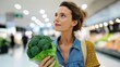 © OleksandrZastrozhnov - Young caucasian female choosing fresh broccoli in grocery store