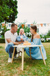 © DSMT - Family celebrates a child's birthday with cake and decorations in an outdoor park setting during the day