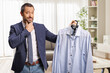 © Ljupco Smokovski - Pensive man holding a shirt on a hanger