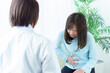 © taka - 病院で診察を受ける女性　腹痛　体調不良