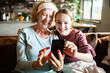 © Geber86 - Senior woman and teen girl taking selfie with face masks at home