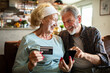 © Geber86 - Happy senior couple shopping online at home