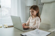 © Miljan Živković - Young girl concentrating on laptop for remote learning at home