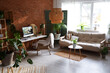 © Pixel-Shot - Blurred view of office with workplace, green plants and sofa