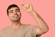 © Pixel-Shot - Young man with vitamin A pill on pink background, closeup