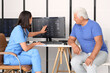 © Pixel-Shot - Female doctor showing x-ray image on computer to senior patient in medical office