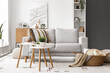 © Pixel-Shot - Interior of light living room with grey sofa, coffee table and wicker basket