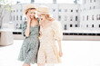 © halayalex - Two young beautiful smiling hipster female in trendy summer dress  clothes. Blond carefree women posing in the street. Positive models having fun at sunny day. Going crazy. In sundress