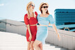 © halayalex - Two young beautiful smiling hipster women in trendy summer same clothes. Carefree models posing in the street. Positive models having fun. Cheerful and happy, at sunny day. In hat and sunglasses