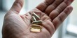 © hobonski - Wellness supplement capsules and golden oil pill in hand for health support and nutrition to achieve physical vitality and daily vitamin body balance.